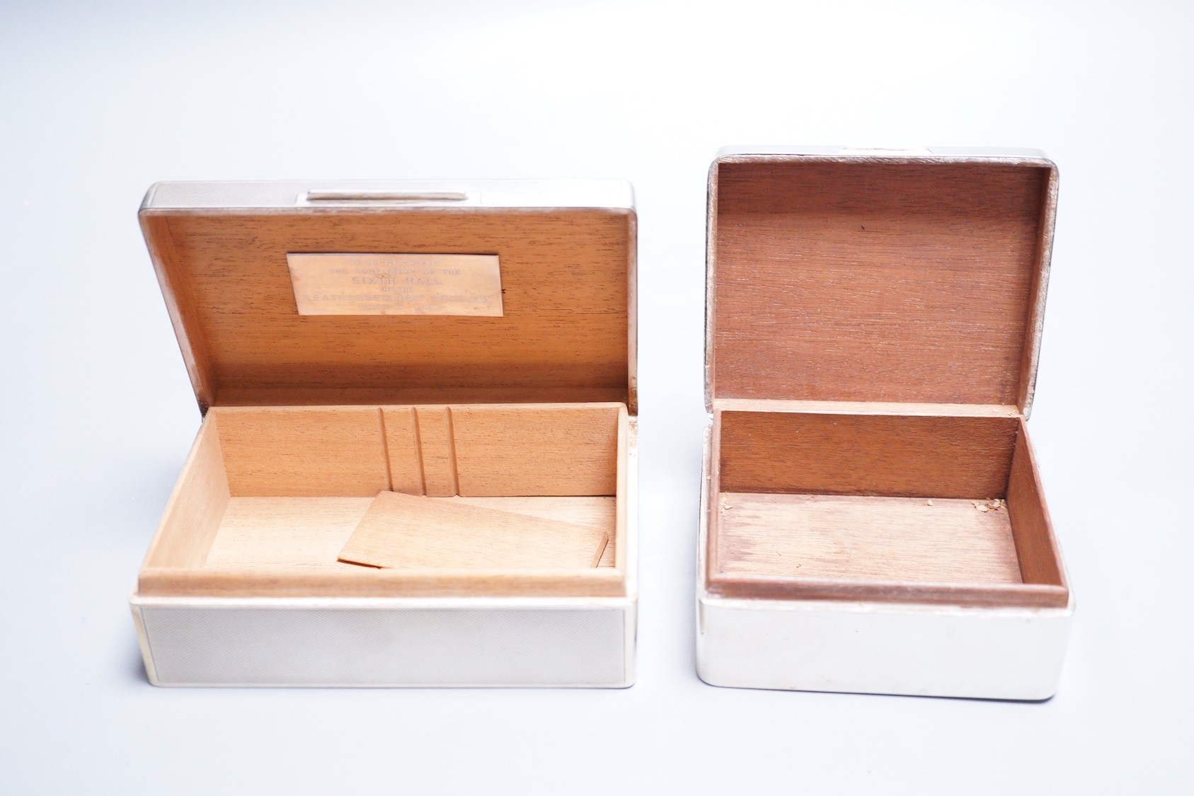 A late 1950's engine turned silver mounted rectangular cigarette box, by Mappin & Webb, 14cm and one other smaller silver mounted cigarette box.